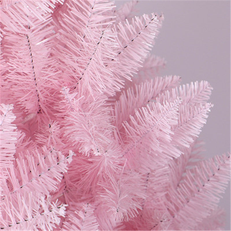 Close-up of pink artificial Christmas tree branches with soft needles on light gray background