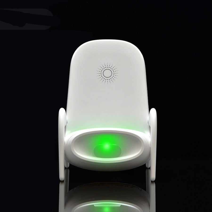 Modern white baby chair with green glowing light and perforated sunburst design on backrest