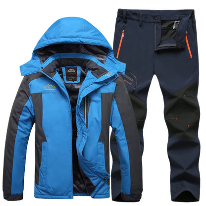 Blue and black waterproof outdoor jacket with hood and insulated lining, paired with black hiking pants with orange zipper pockets