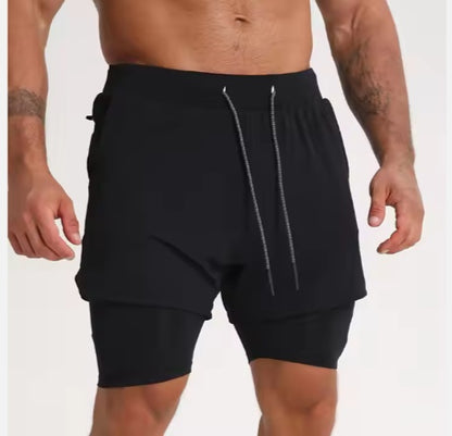 Athletic man wearing black layered gym shorts with drawstring detail