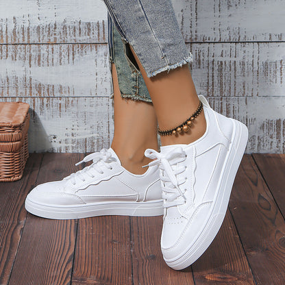 White platform sneakers with laces worn with blue frayed hem jeans and bronze beaded ankle bracelet