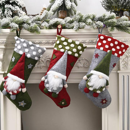 Three festive Christmas stockings with gnome decorations hanging on a white fireplace mantel with snowy pine garland
