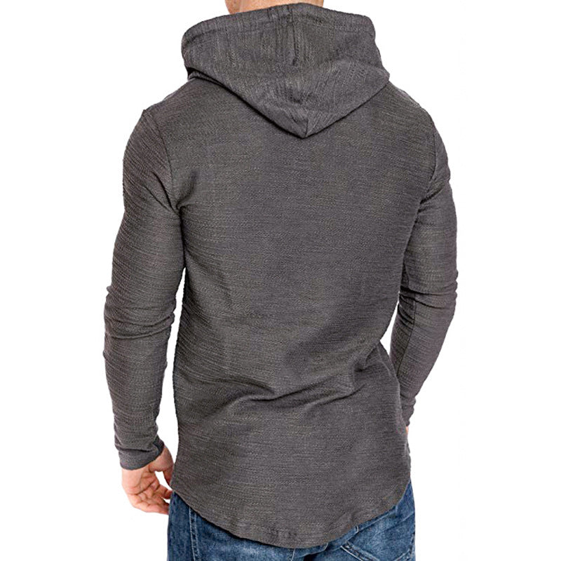 Back view of man wearing dark grey textured hoodie and blue jeans on white background
