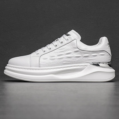 White men's fashion sneaker with textured side panel, thick sole, and metallic heel detail on gray background