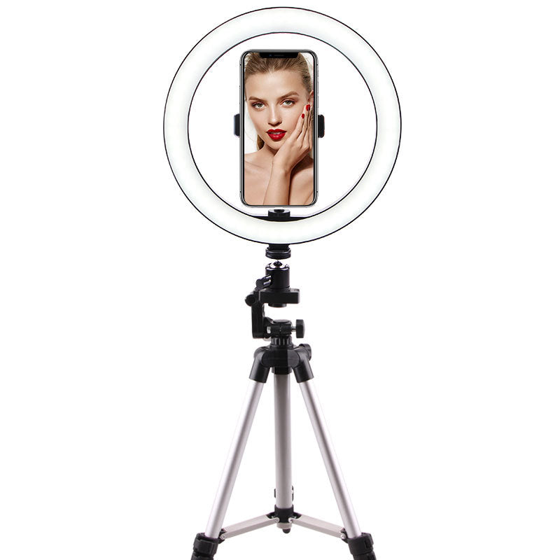 Ring light on tripod with smartphone holder displaying a woman with red lipstick and nails