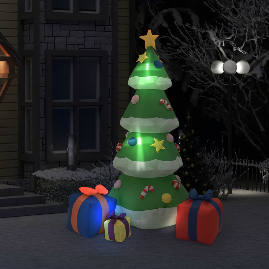 Inflatable Christmas tree decorated with candy canes and stars, surrounded by wrapped gift boxes at night