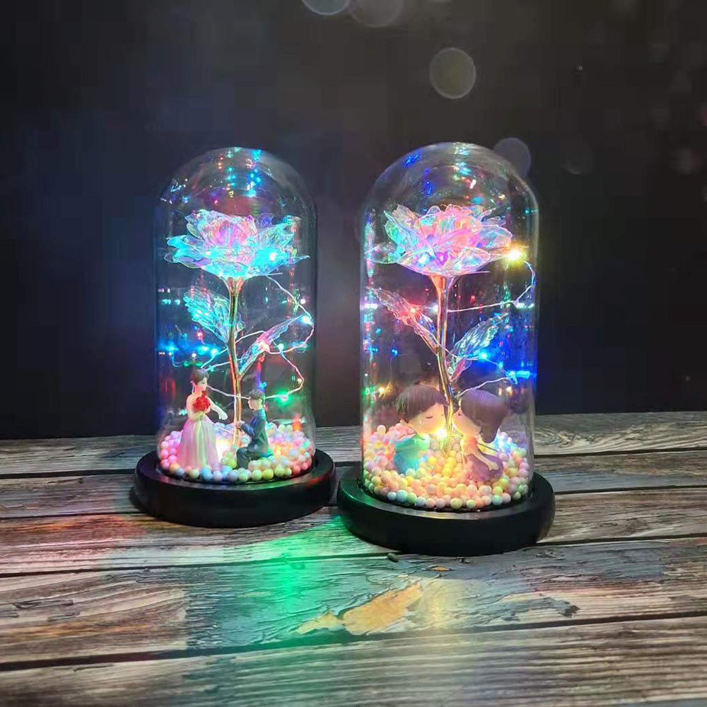 Two glass dome decorations with colorful LED-lit roses and cute miniature couple figures inside