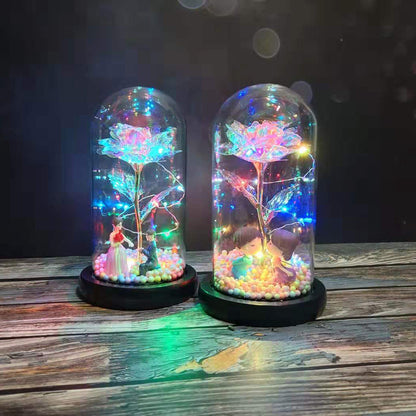 Two glass dome decorations with colorful LED-lit roses and cute miniature couple figures inside