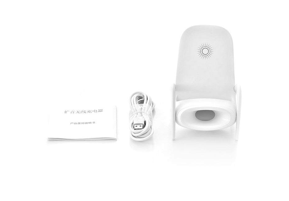 White wireless charger stand with speaker, USB cable, and instruction manual on white background
