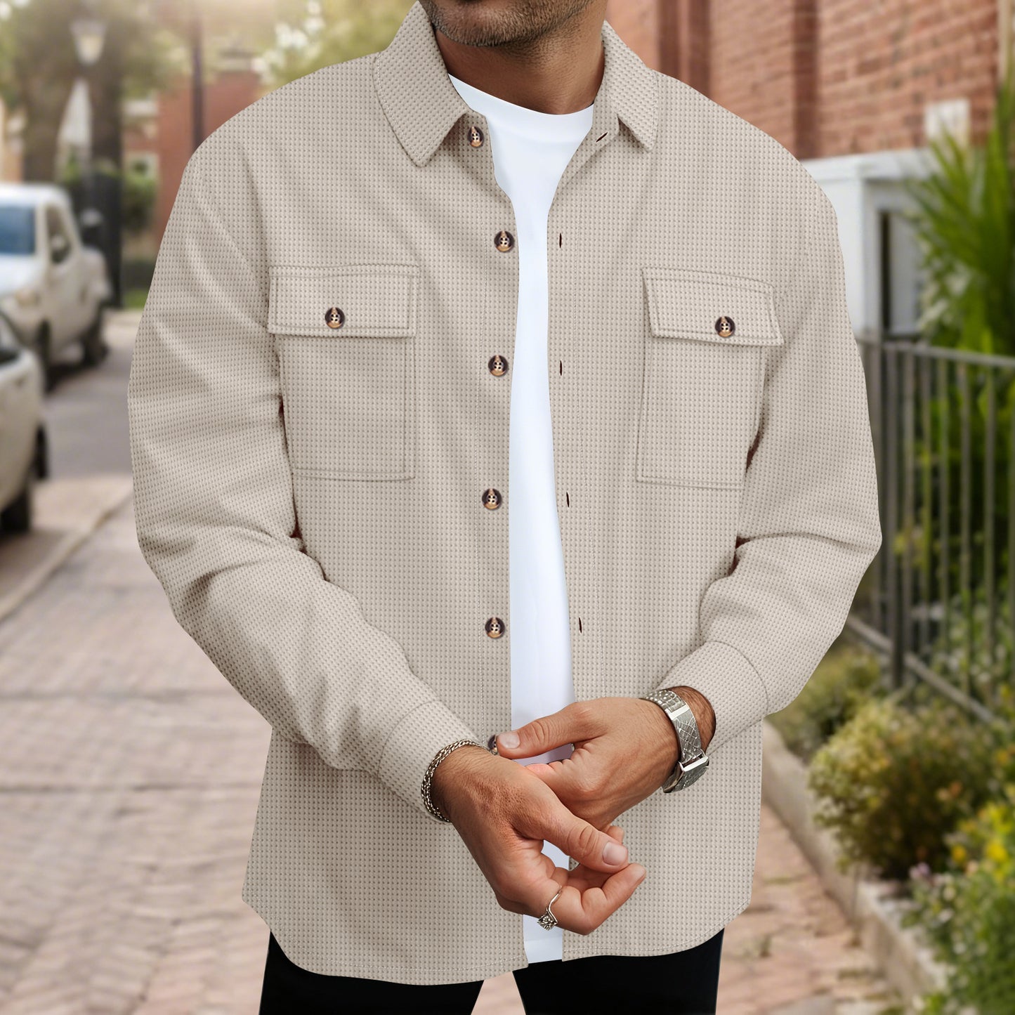 Man wearing beige textured button-up shirt jacket with two flap chest pockets and white t-shirt