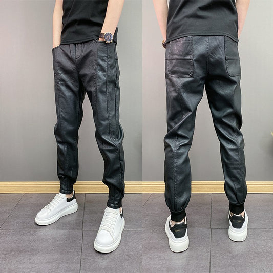 Man wearing black leather jogger pants with front and back pockets, paired with white sneakers and black t-shirt