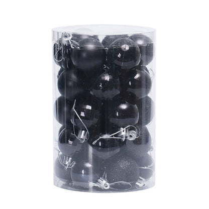 Transparent cylindrical container filled with black matte and glossy Christmas baubles