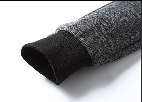 Close-up of grey sweatshirt sleeve with black ribbed cuff on white background