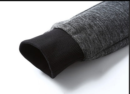 Close-up of grey sweatshirt sleeve with black ribbed cuff on white background