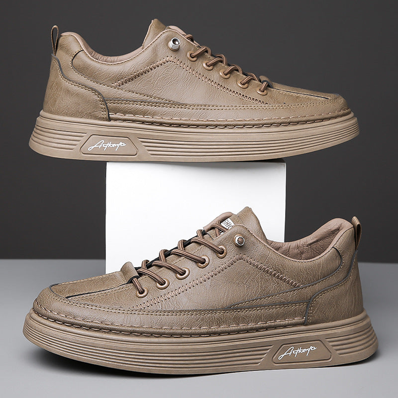 Brown leather casual sneakers with thick soles displayed on white platform against dark background