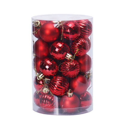 Clear cylindrical container filled with assorted red Christmas baubles with shiny and matte finishes