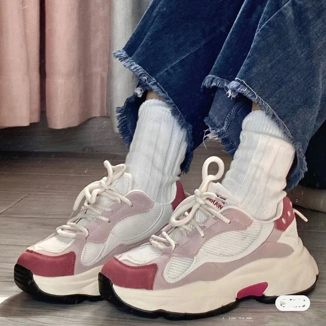 Trendy outfit featuring platform sneakers with pink and white accents, white socks, and frayed blue jeans