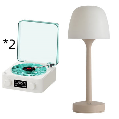 White retro turntable with turquoise vinyl and transparent lid, next to beige modern table lamp