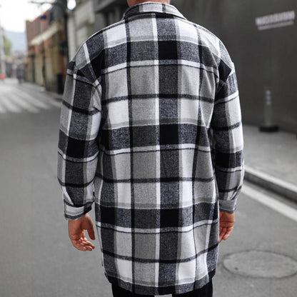 Man wearing black and white plaid flannel shirt jacket standing on urban street
