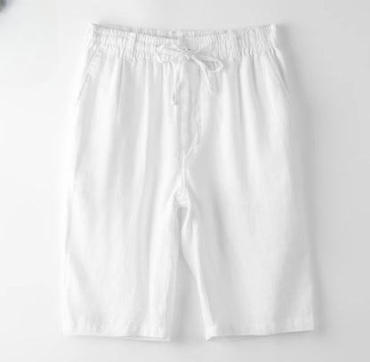White cotton drawstring shorts with side pockets, laid flat on white background