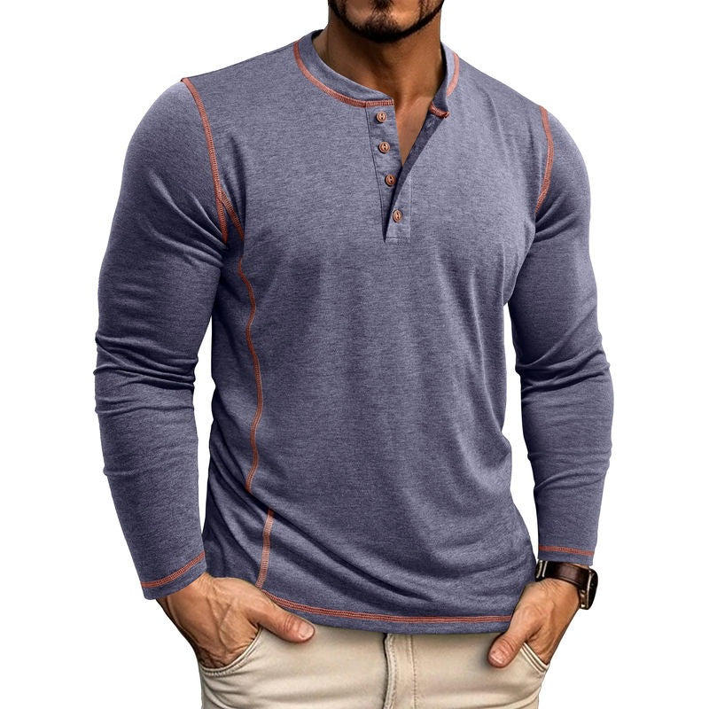 Men's long sleeve henley shirt in blue with orange contrast stitching, worn with beige pants