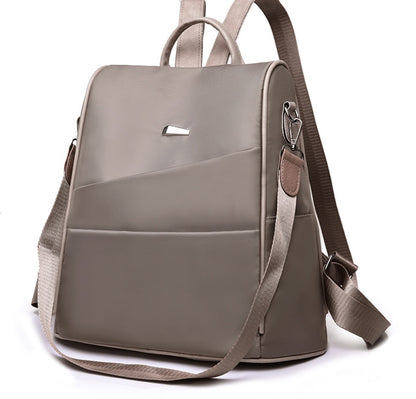 taupe nylon backpack with front pocket, top handle, and adjustable shoulder straps