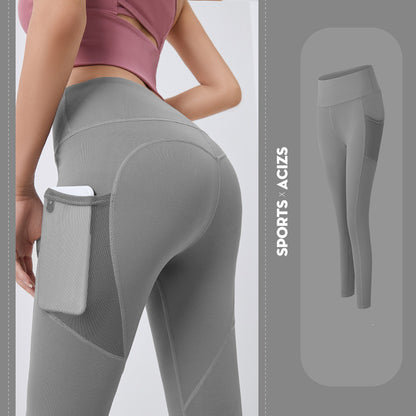 Woman wearing gray high-waisted sports leggings with side mesh pocket holding phone