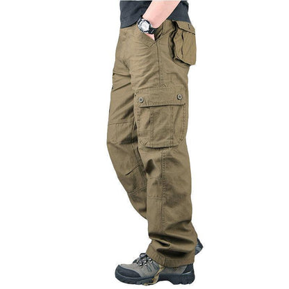 Side view of man wearing olive green cargo pants with multiple pockets and gray hiking shoes