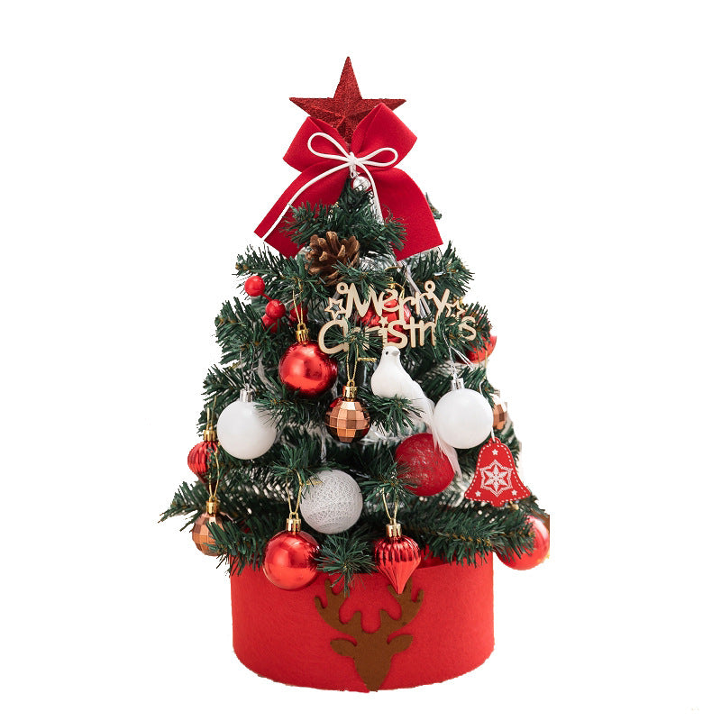 Small decorated Christmas tree with red and white ornaments, red bow, pinecone, and reindeer base