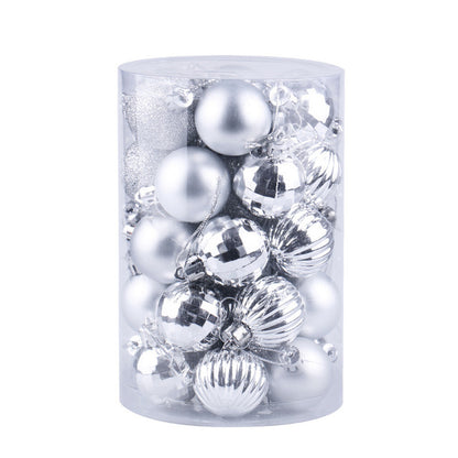 Clear cylindrical container filled with assorted silver Christmas ornaments in matte, shiny, glitter, and ribbed textures