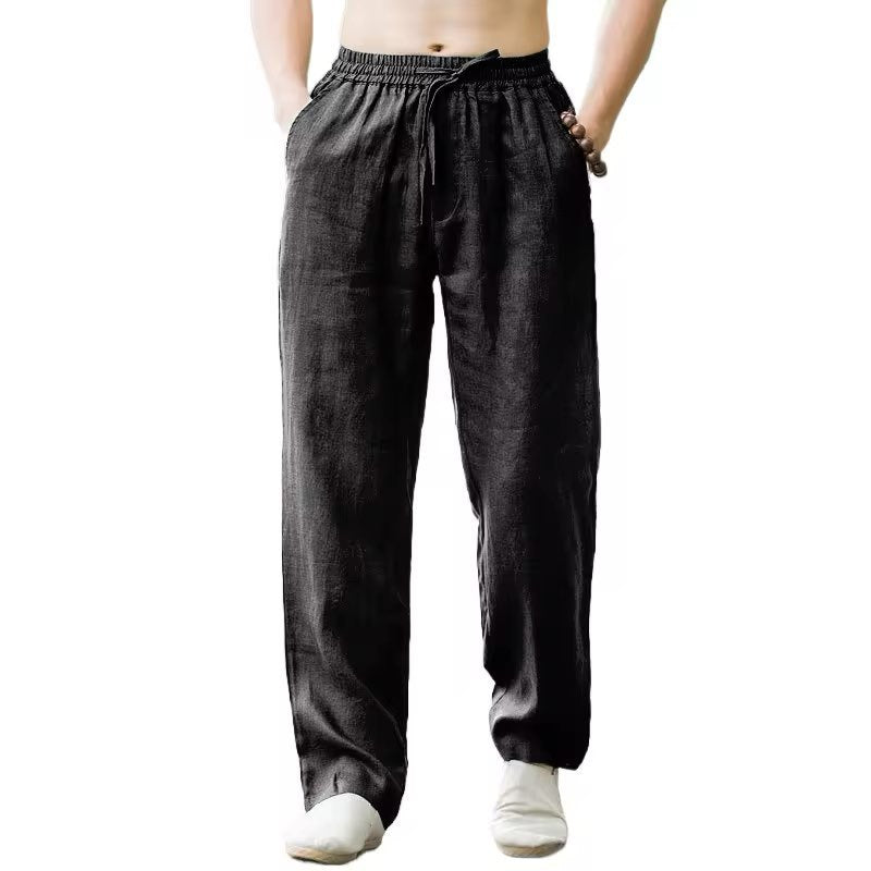 Men's black casual linen pants with elastic waist and drawstring, styled with white shoes