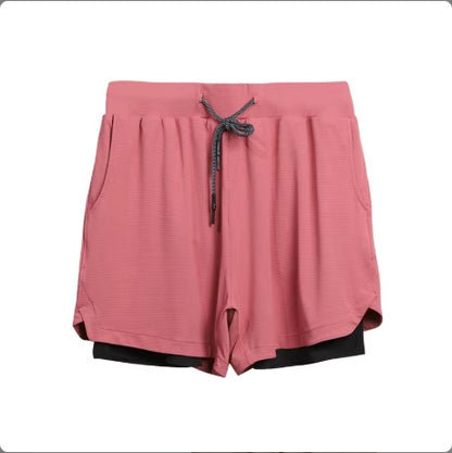 Pink women's layered athletic shorts with black inner layer and adjustable drawstring waistband