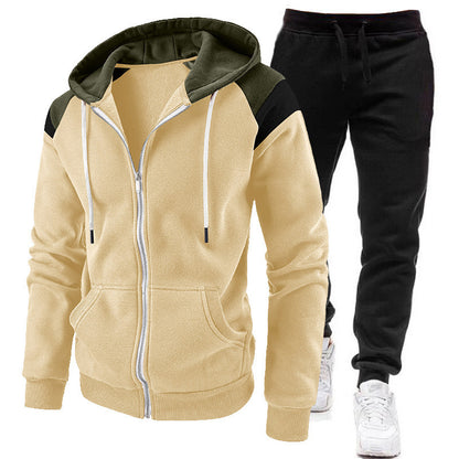 Beige zip-up hoodie with olive green and black accents and black jogger pants with white sneakers