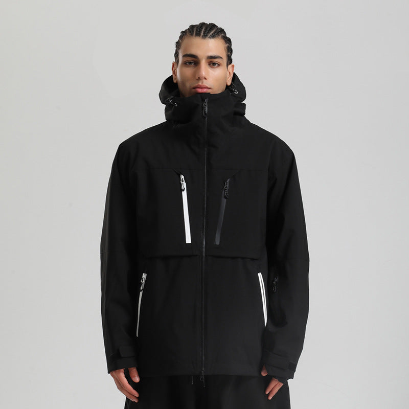 Man wearing black winter jacket with white and black zipper details and hood on gray background