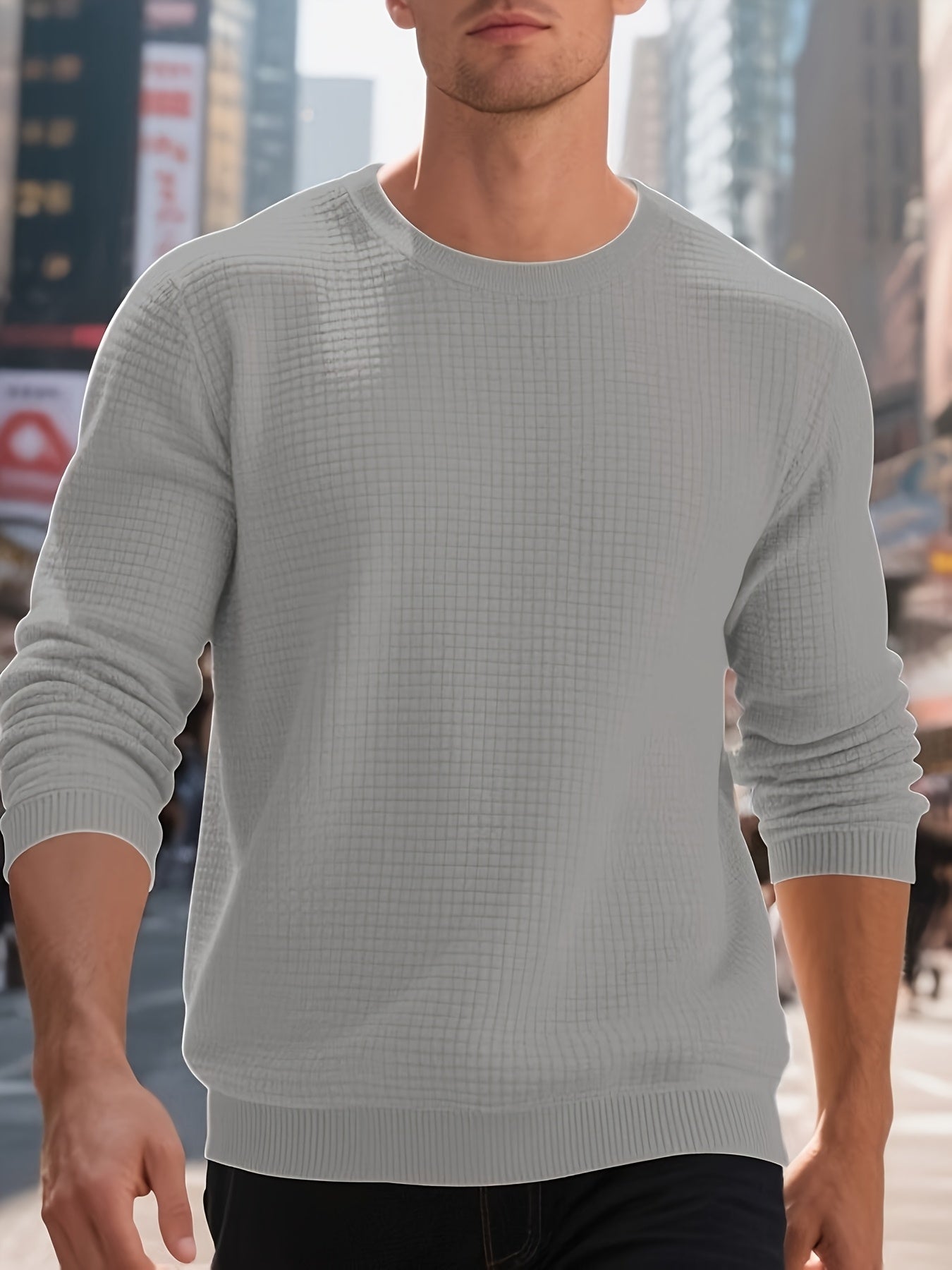 Man wearing light gray textured crewneck sweater walking in urban city street