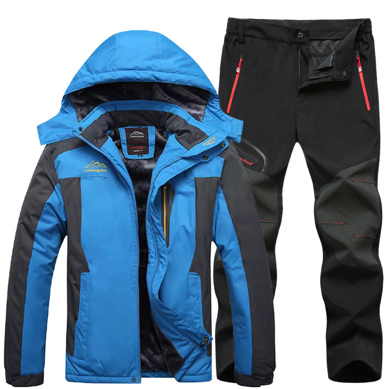 Blue and black waterproof outdoor jacket with hood and black hiking pants with red zipper pockets