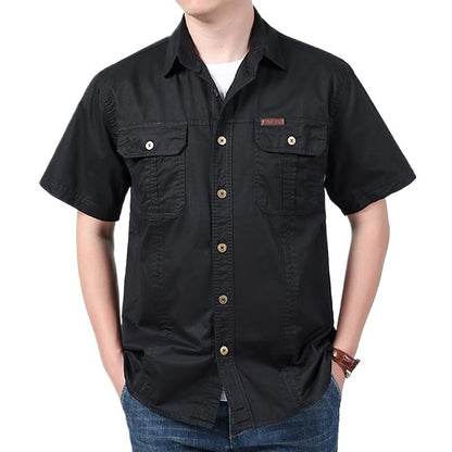 man wearing black short sleeve button-up shirt with chest pockets and blue jeans