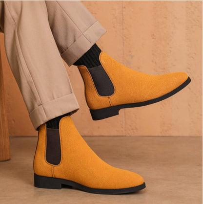 Mustard suede Chelsea boots with black elastic sides worn with beige pants and black socks