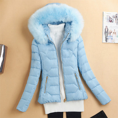 Light blue quilted puffer jacket with fluffy hood paired with white turtleneck sweater on beige background