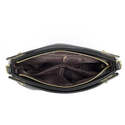 Open black leather handbag with gold zipper showing multiple inner compartments and pockets