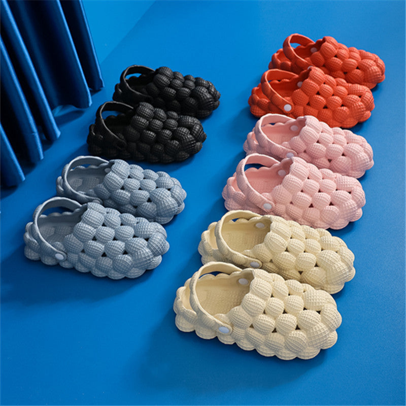 Colorful bubble-textured casual sandals in black, orange, pink, blue, and yellow on blue surface