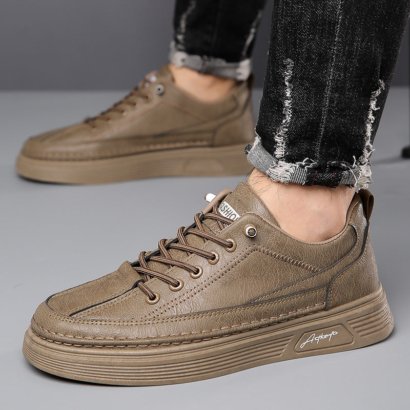 Brown leather casual sneakers with textured sole and stitched detailing worn with black distressed jeans