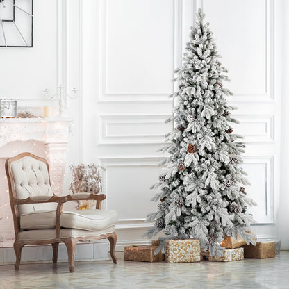 Elegant white living room with a frosted Christmas tree decorated with pinecones and gold wrapped gifts