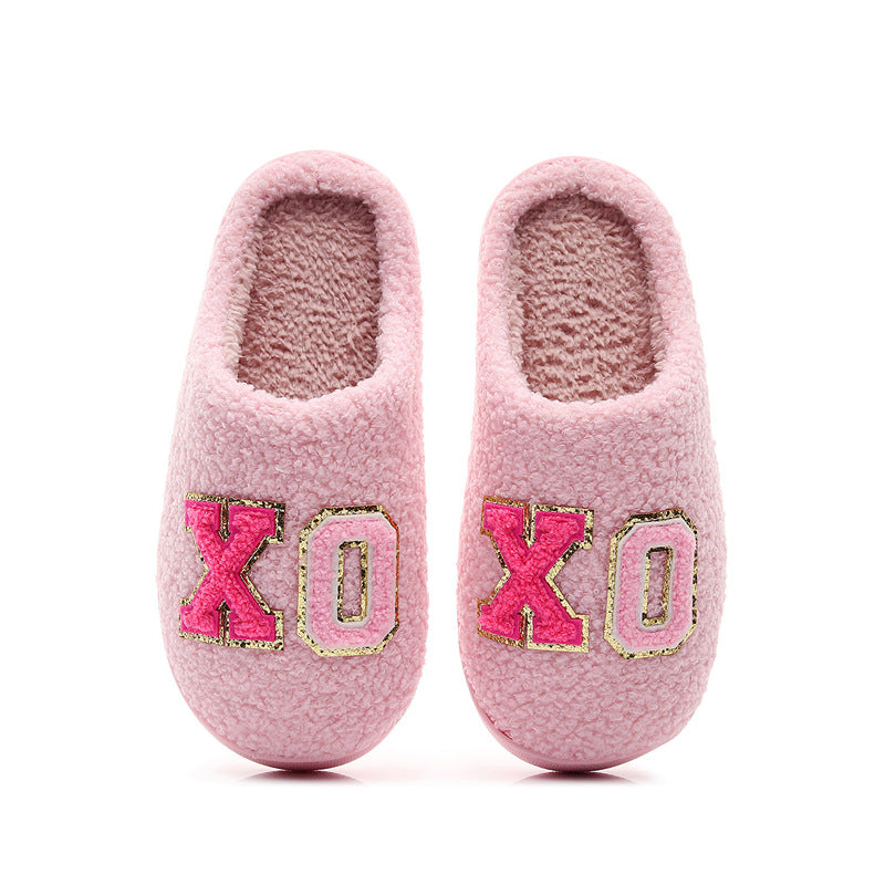 Cozy pink fuzzy slippers with gold-trimmed XO embroidery, warm indoor footwear