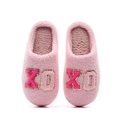 Cozy pink fuzzy slippers with gold-trimmed XO embroidery, warm indoor footwear
