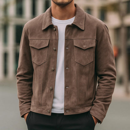 Man wearing a brown suede jacket and white t-shirt outdoors in urban setting