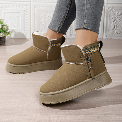 Women's olive green winter ankle boots with fur lining and platform soles worn with gray jeans indoors