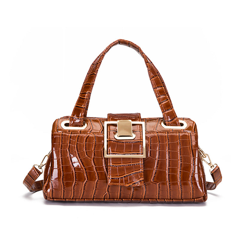 Brown crocodile pattern leather handbag with gold buckle and double handles on white background