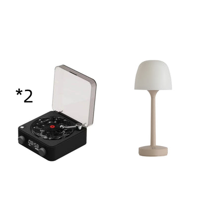 Black mini turntable with transparent lid and beige modern table lamp with white shade on white background