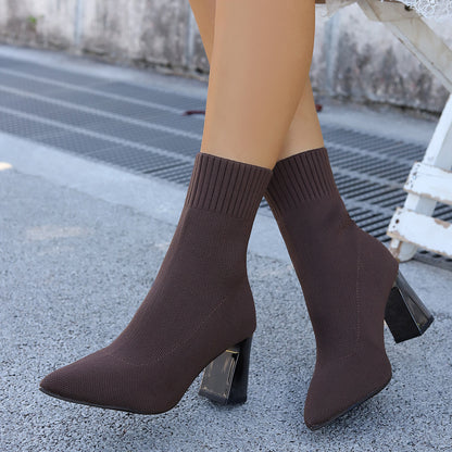 Brown knit sock boots with block heels worn outdoors on gray pavement